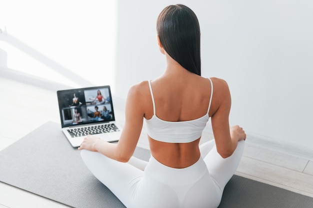 Con laptop Mujer caucásica joven con forma de cuerpo delgado está en el interior durante el día