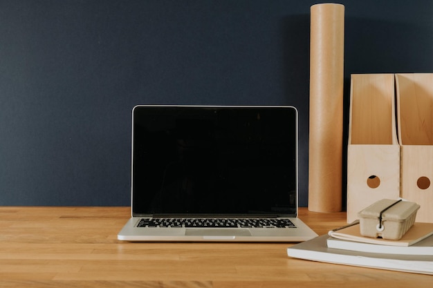 Laptop na mesa de madeira com acessórios de escritório