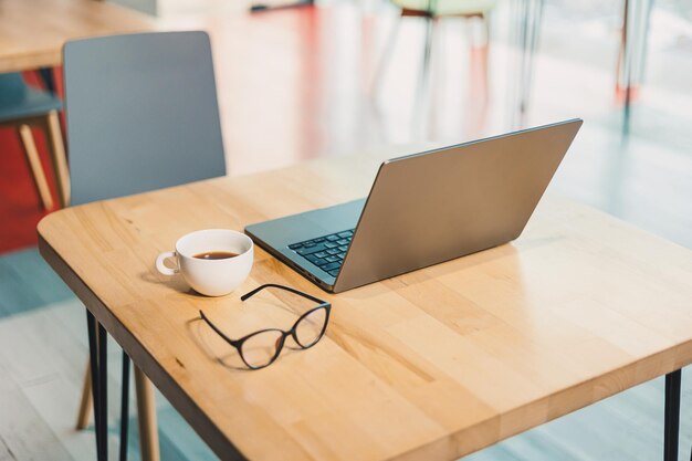 Foto laptop neben gläsern und einer tasse kaffee