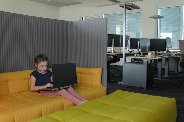 Foto laptop para niños, sofá amarillo para la oficina.