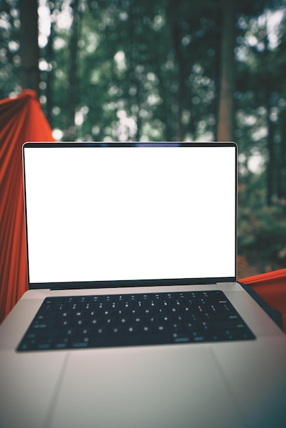 Laptop de un nómada digital remoto en una hamaca con fondo de bosque verde primera perspectiva trabajando en una laptop moderna mientras está en la naturaleza