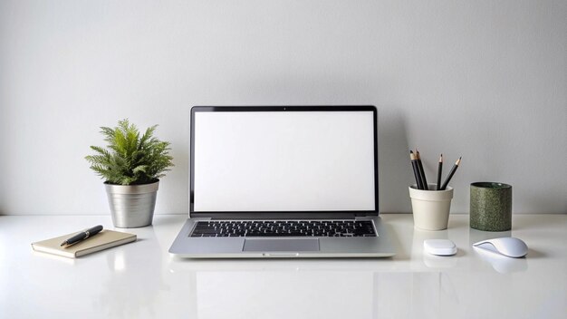 Laptop, notebook, caneta, rato e planta em mesa branca