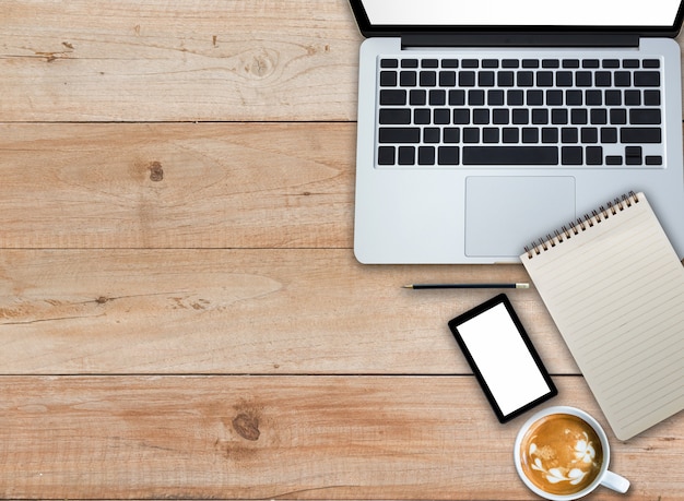 Laptop Notizblock Smartphone und Kaffee auf Holztisch