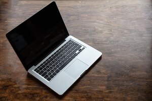 Foto laptop con pantalla negra en blanco en un escritorio de madera