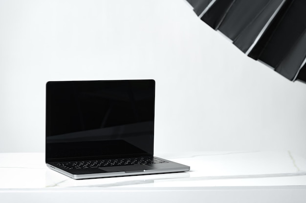 Laptop con pantalla negra y equipo fotográfico en el estudio fotográfico