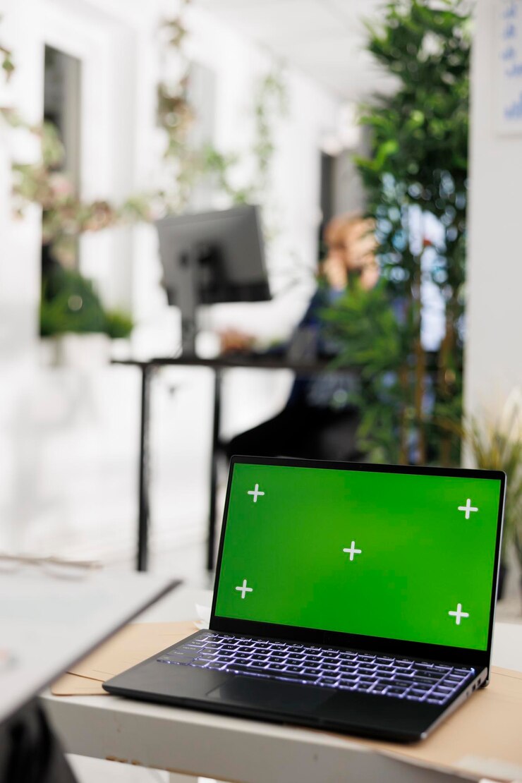 Foto laptop con pantalla verde en el escritorio de la oficina de negocios para la presentación financiera. ordenador portátil con pantalla vacía para el informe financiero en el espacio de coworking corporativo