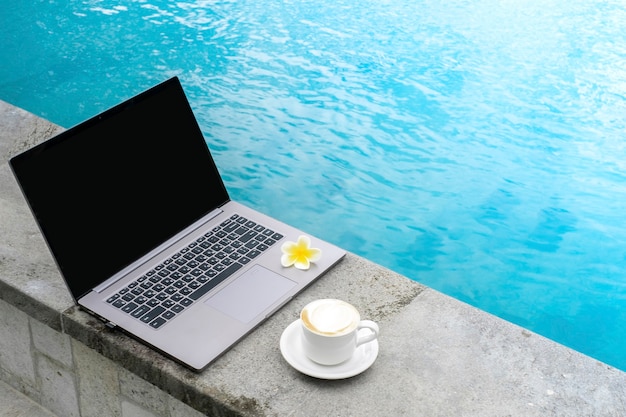 Laptop en la piscina con una taza de café