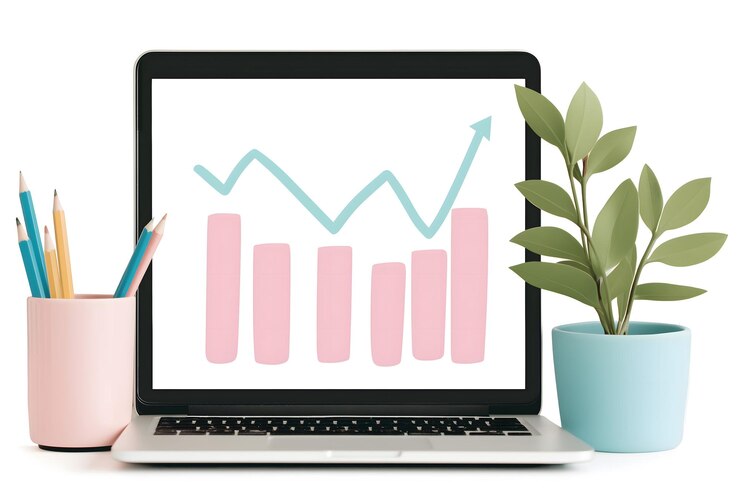 Foto laptop que muestra un gráfico de crecimiento con barras ascendentes y gráfico de líneas rodeado de lápices de colores y una planta que simboliza la productividad, la creatividad y el progreso en los negocios o la educación