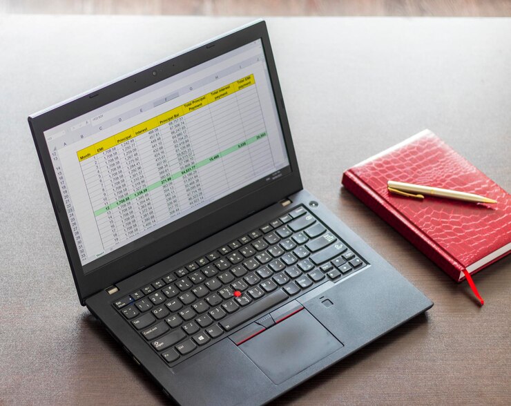 Foto laptop que muestra una hoja de excel en la pantalla con la tabla de amortización de préstamos bancarios finanzas
