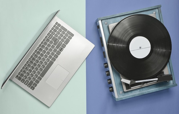 Laptop, reproductor de vinilo sobre un fondo pastel de color