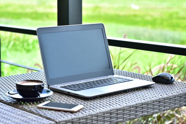 Laptop, Smartphone &amp; Tasse Kaffee auf Coffee-Shop-Tisch, niemand