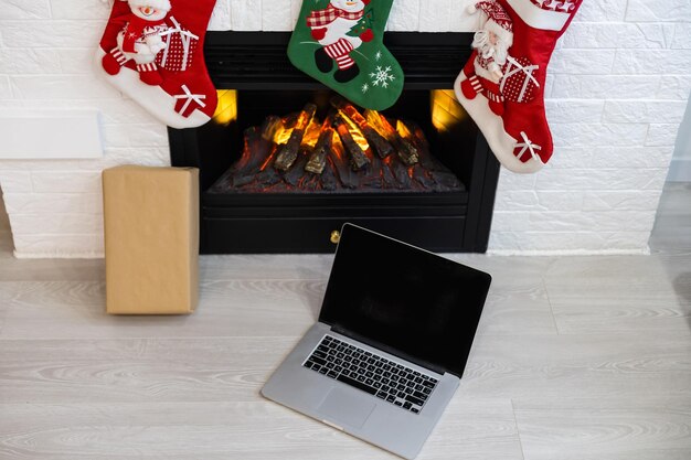 Laptop steht neben dem Kamin, Weihnachten