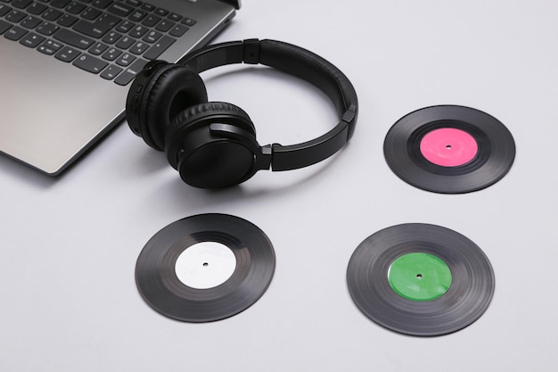 Laptop-Stereokopfhörer mit Schallplatten auf weißem Hintergrund