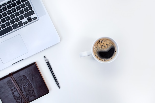Laptop und eine Tasse Kaffee auf einem Schreibtisch