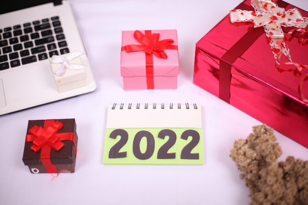 Laptop und Geschenkbox für Neujahrsfeier isoliert auf weißem Hintergrund
