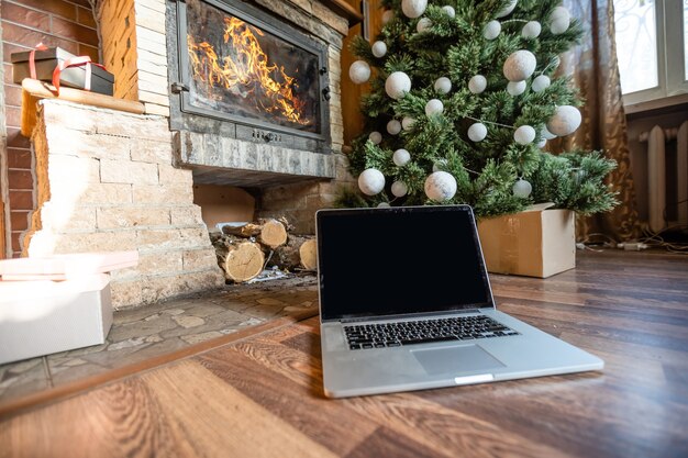 Laptop und Weihnachtsbaum in einem alten Holzhaus