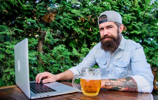 Laptop unterstützt weiterhin virtuelle Mitarbeiter Laptop-Benutzer trinken Bier im Café im Freien Bärtiger Mann, der am Laptop arbeitet Hipster mit Laptop mit kostenlosem Internetzugang