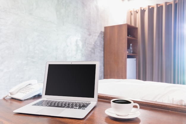 Laptops com caneca de café branco na mesa de madeira