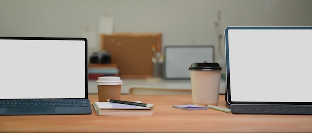 Laptops com telas brancas e xícaras de café