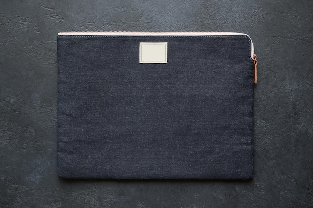 Laptoptasche aus schwarzem Denim auf dunklem Hintergrund