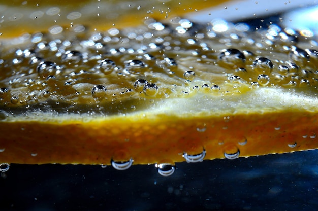 Laranja em água com gás com bolhas. macro.