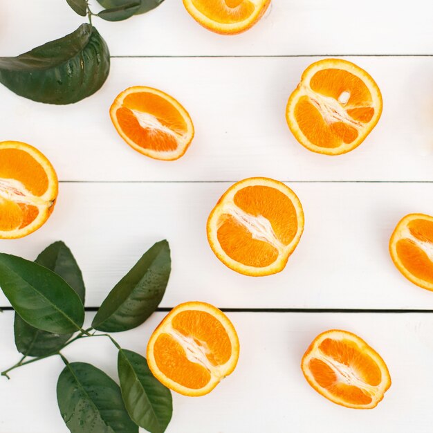 Laranja fresca com folhas em uma mesa de madeira branca