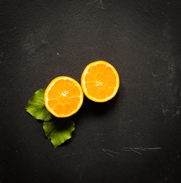 Laranja fresca com folhas na mesa de madeira