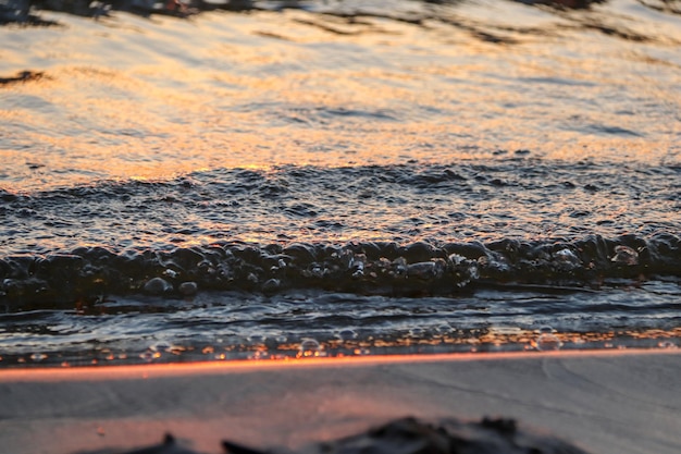 Foto laranja pôr do sol sobre a baía com ondas pequenas