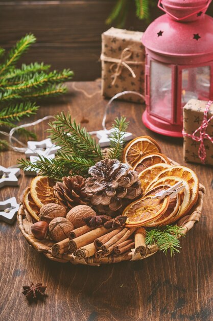 Laranja seca, anis estrelado, canela, pinhas e abeto em placa rústica na mesa de madeira. Idéia de medley caseiro para clima e aroma de Natal. Eco amigável Natal com decorações naturais caseiras.