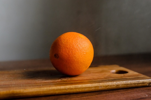 Laranja suculenta em uma placa de madeira.