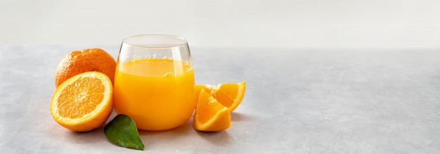 Laranjas e copo de suco de laranja fresco