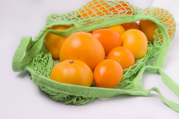 laranjas em uma sacola ecológica em um fundo branco