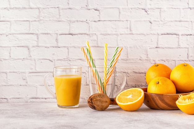 Laranjas frescas em uma tigela com suco de laranja