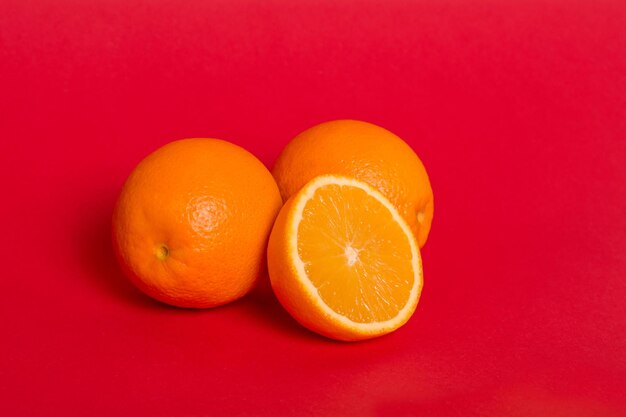 Laranjas maduras em um fundo vermelho meia laranja suculenta