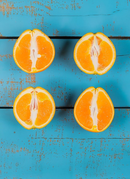 Foto laranjas orgânicas frescas em meias frutas em fundo de madeira azul com espaço de cópia