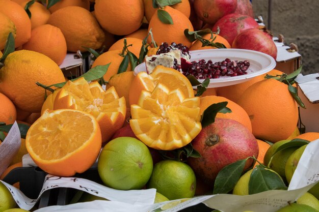 Laranjas, romãs e outras frutas cítricas num mercado de agricultores