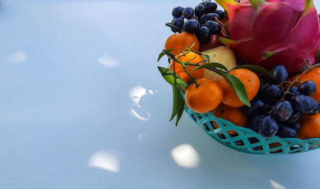 Laranjas tropicais da fruta do dragão, peras, uvas à direita em um fundo branco 01