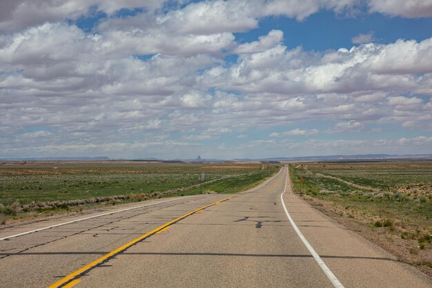 Larga carretera cielo azul nublado Monument Valley Navajo nación ArizonaUtah EE.UU.