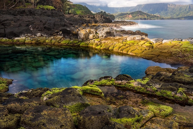 Larga exposición de las tranquilas aguas de Queen's Bath, una piscina de roca frente a Princeville en la costa norte de Kauai