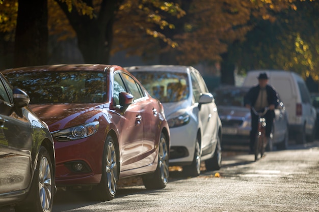 Larga fila de automóviles estacionados a lo largo de la carretera vacía