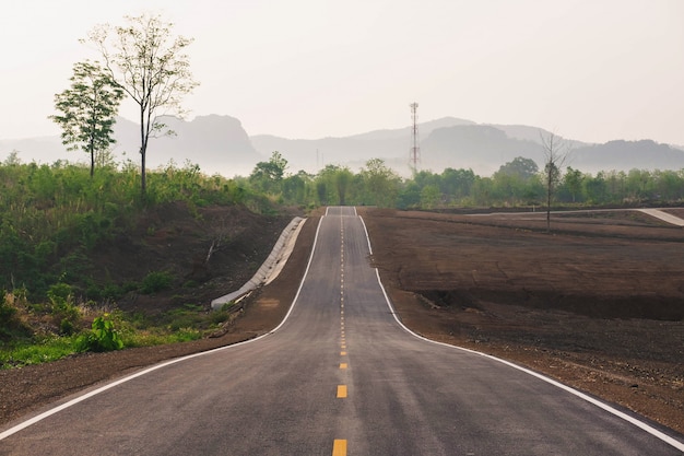 Un largo camino recto que conduce hacia una montaña