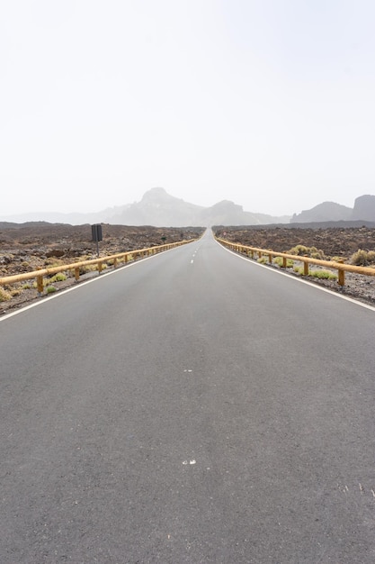 Largo camino vacío con montañas