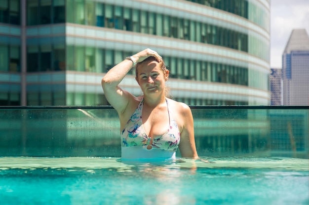 Foto el largo completo de un joven en la piscina