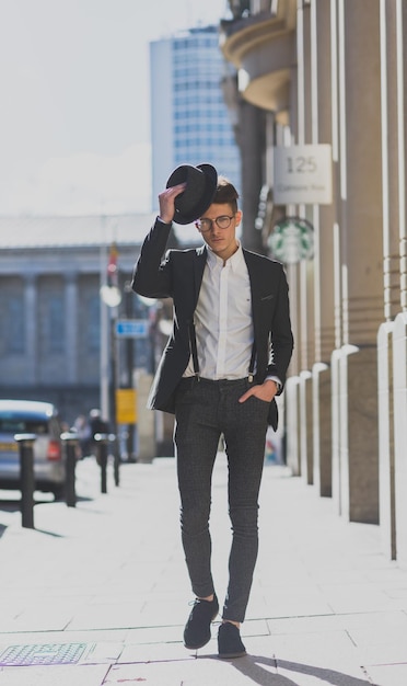El largo de un hombre caminando por la calle de la ciudad