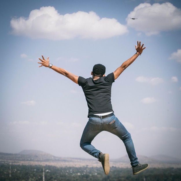 El largo de un hombre saltando contra el cielo