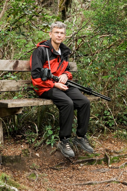 Foto el largo de un joven mirando hacia el bosque.