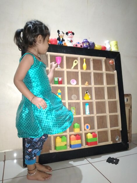 Foto largura completa de un niño lindo jugando con la pelota en casa