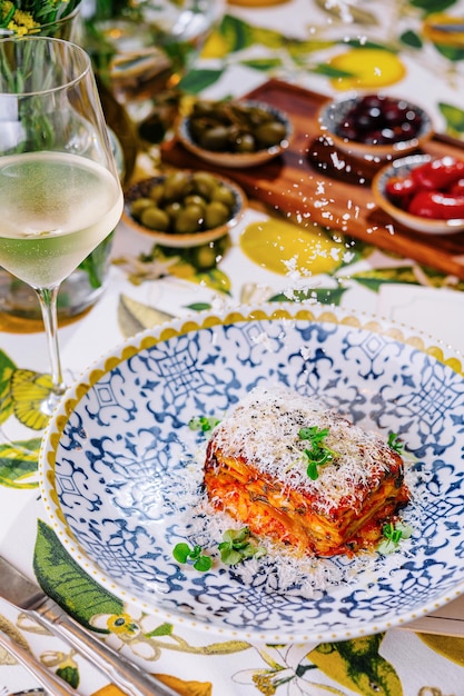 Foto lasagne mit einem glas weißwein