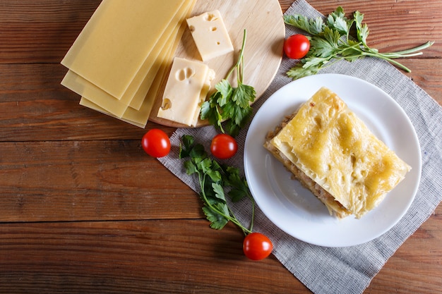 Lasagne mit Hackfleisch und Käse auf braunem hölzernem Hintergrund.