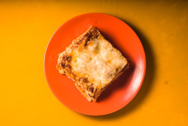 Lasaña de carne casera en espacio de copia de plato naranja